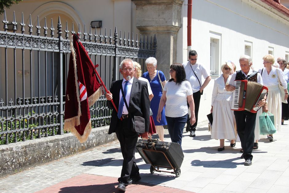 Pék László a 2014-ben átadott kóruszászlóval. Akár utazó színében is tetszeleghetne a kétkerekű kiskocsival, ne tévedjünk: egy, a kórustalálkozón hamarosan megszólaló hangszer szállításában segédkezik 